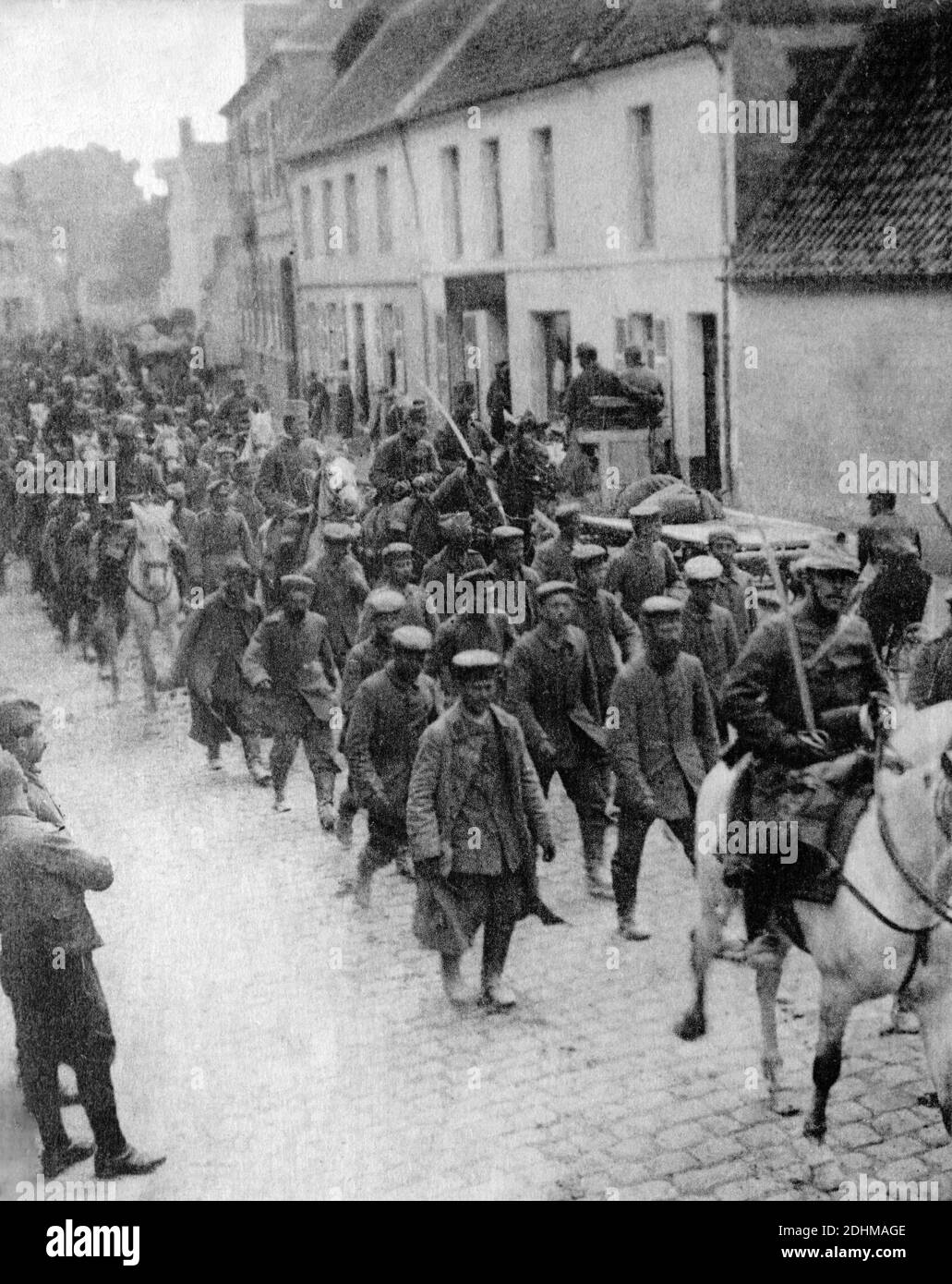 Ein historisches Foto einer Gruppe von 250 deutschen Prisonern, die von Französisch cavarly durch Aubigny, Aubigny-en-Artois, Pas-de-Calais, Frankreich, begleitet wurden, aufgenommen aus einer Postkarte um 1914-1916. Stockfoto