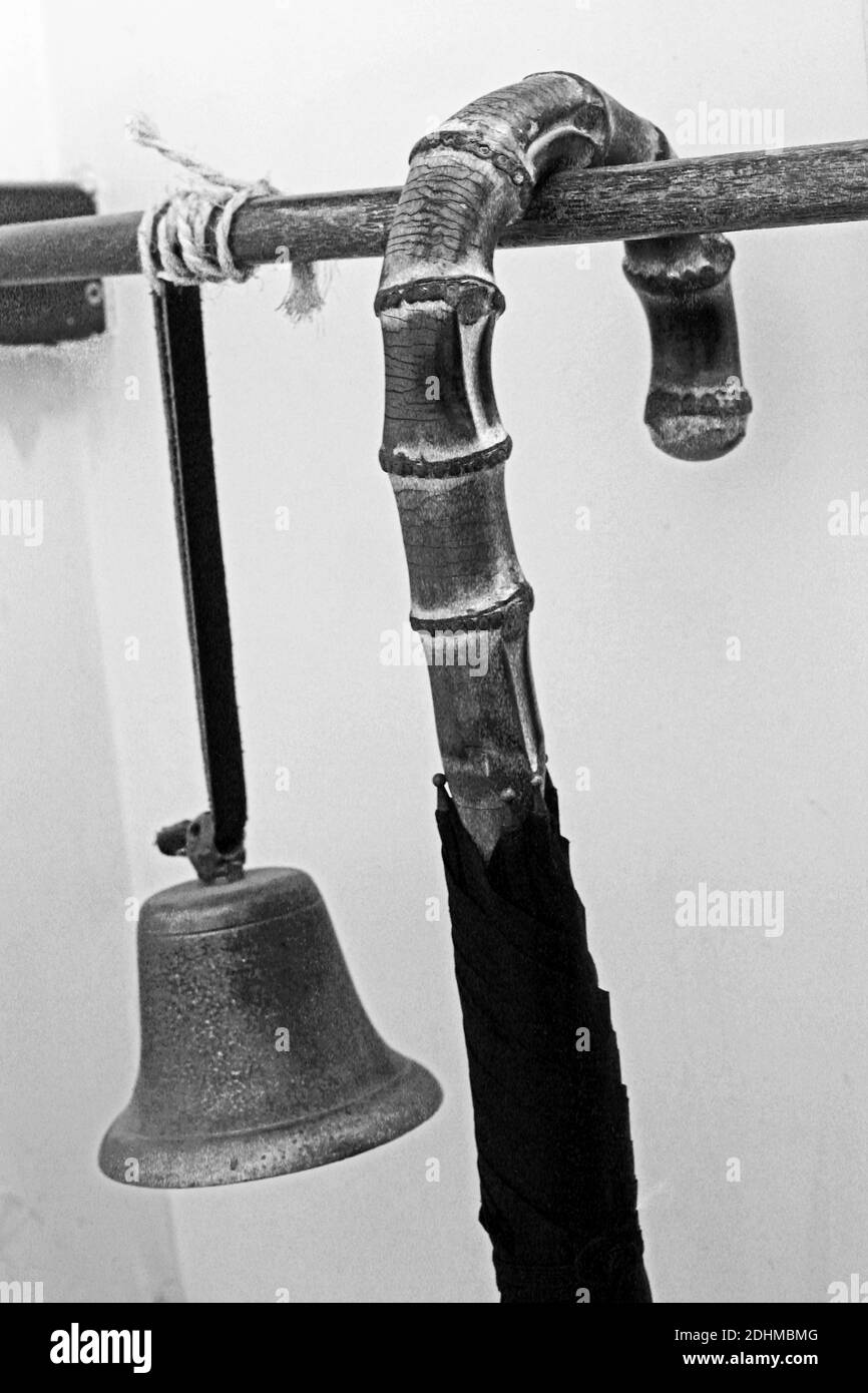 Im historischen James Smith & Sons Dachgeschäft in London signalisiert der Handwerker in der Kellerwerkstatt die Fertigstellung eines Sonnenschirms. Stockfoto