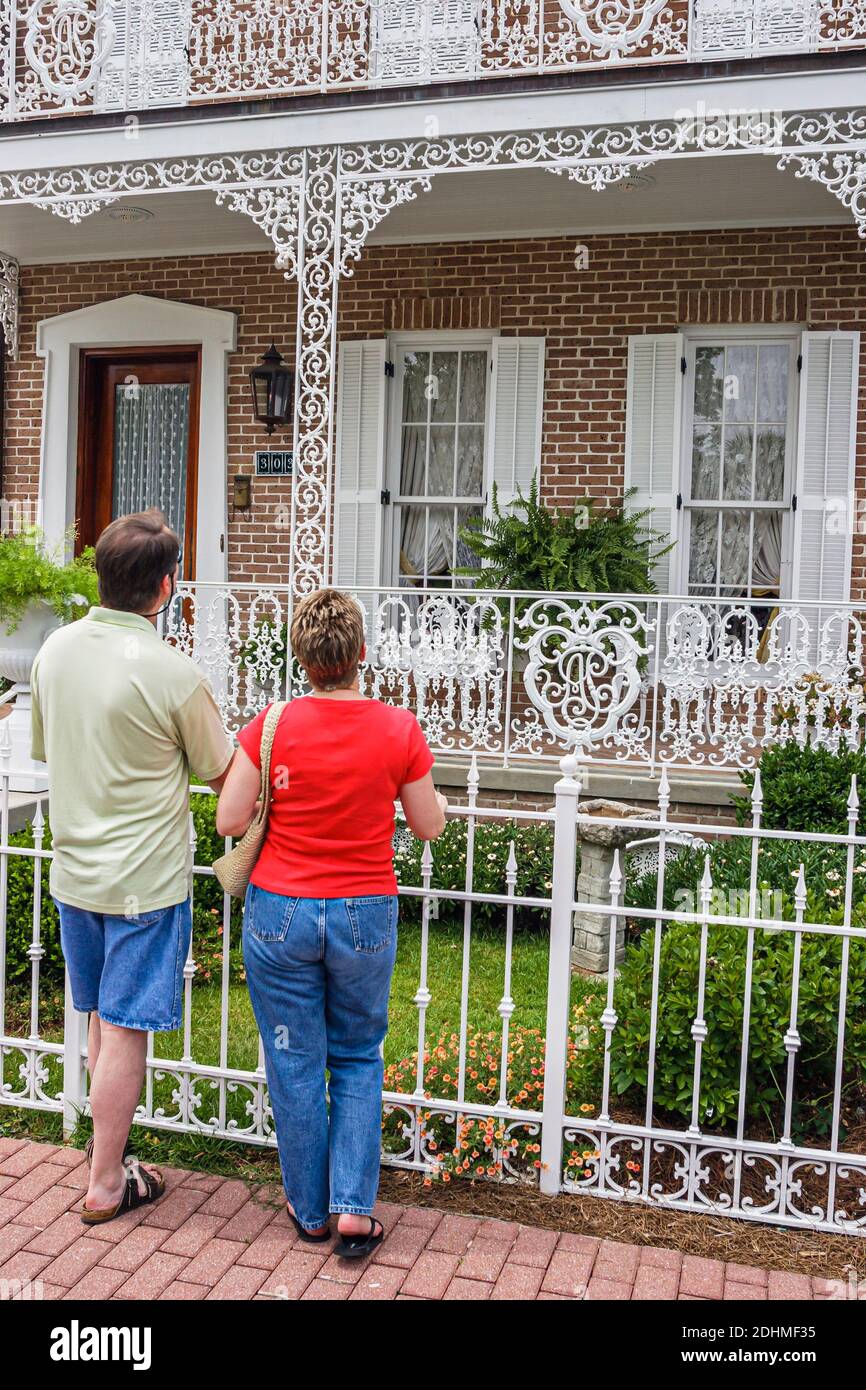 Alabama Fairhope De la Mare Street Paar Mann Frau, schmiedeeiserne Geländer Zaun nach Hause schauen, Stockfoto