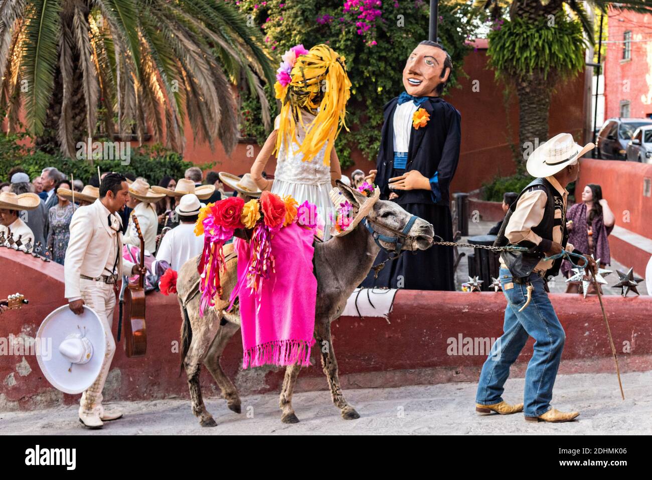 Eine traditionelle mexikanische Mariachi-Band spielt als riesige Puppen namens Mojigangas Tanz während einer Hochzeitsfeier im Lavaderos del Chorro Park in San Miguel de Allende, Guanajuato, Mexiko. Stockfoto