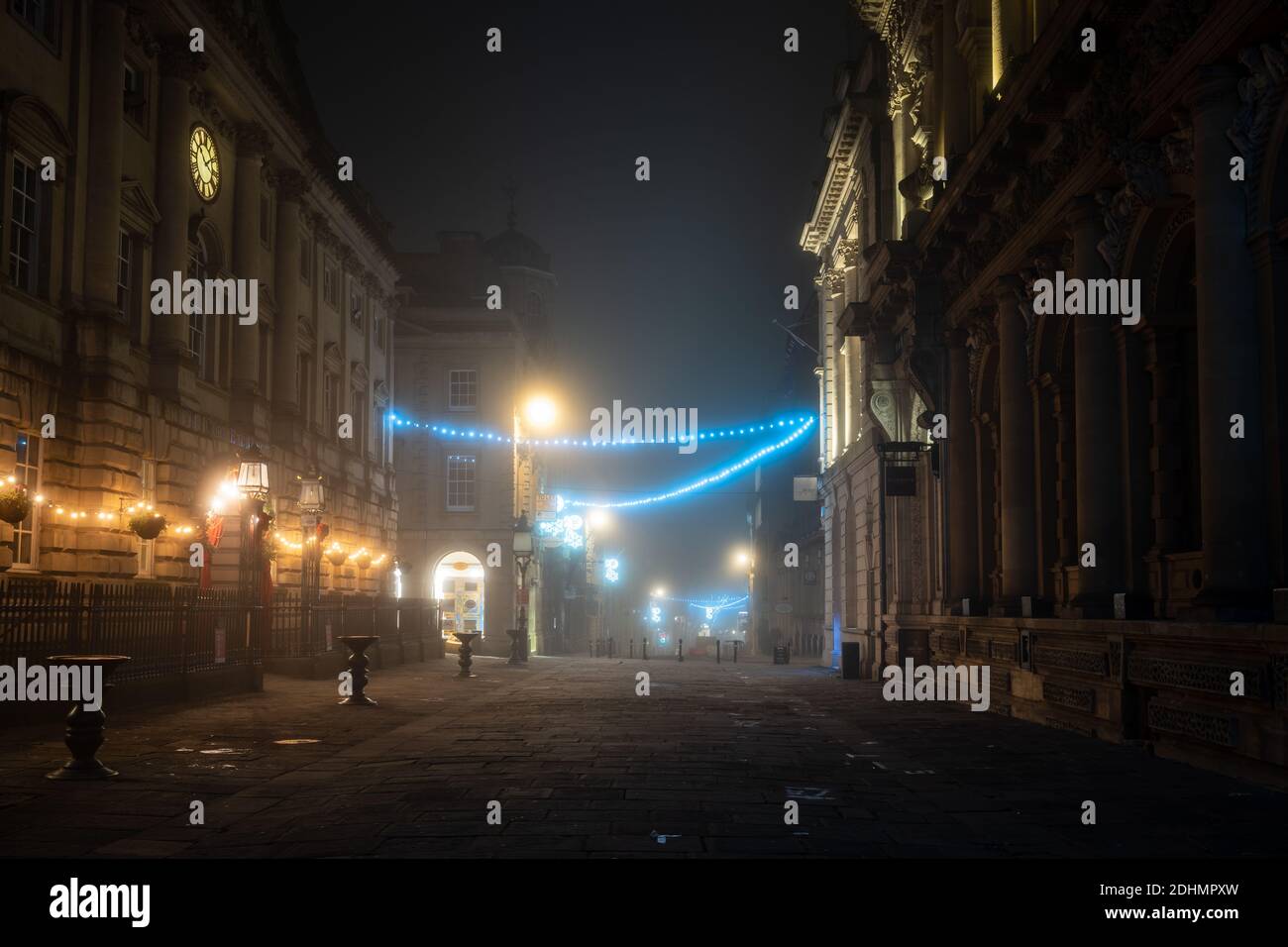 An einer Winternacht auf der Corn Street in Bristol sind Weihnachtsdekorationen in Nebel gehüllt. Stockfoto