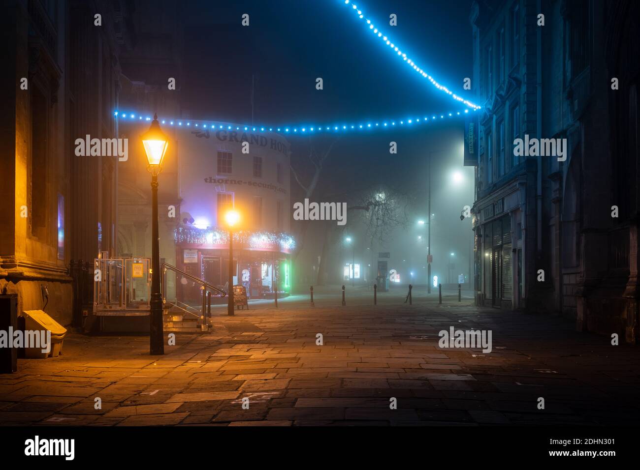An einer Winternacht auf der Corn Street in Bristol sind Weihnachtsdekorationen in Nebel gehüllt. Stockfoto