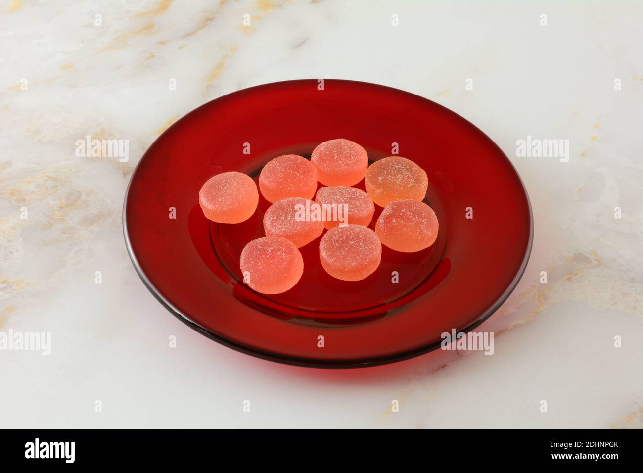 Süße Wassermelone Gummy Süßigkeiten Stücke auf kleinen roten Dessertplatte Auf dem Tisch Stockfoto