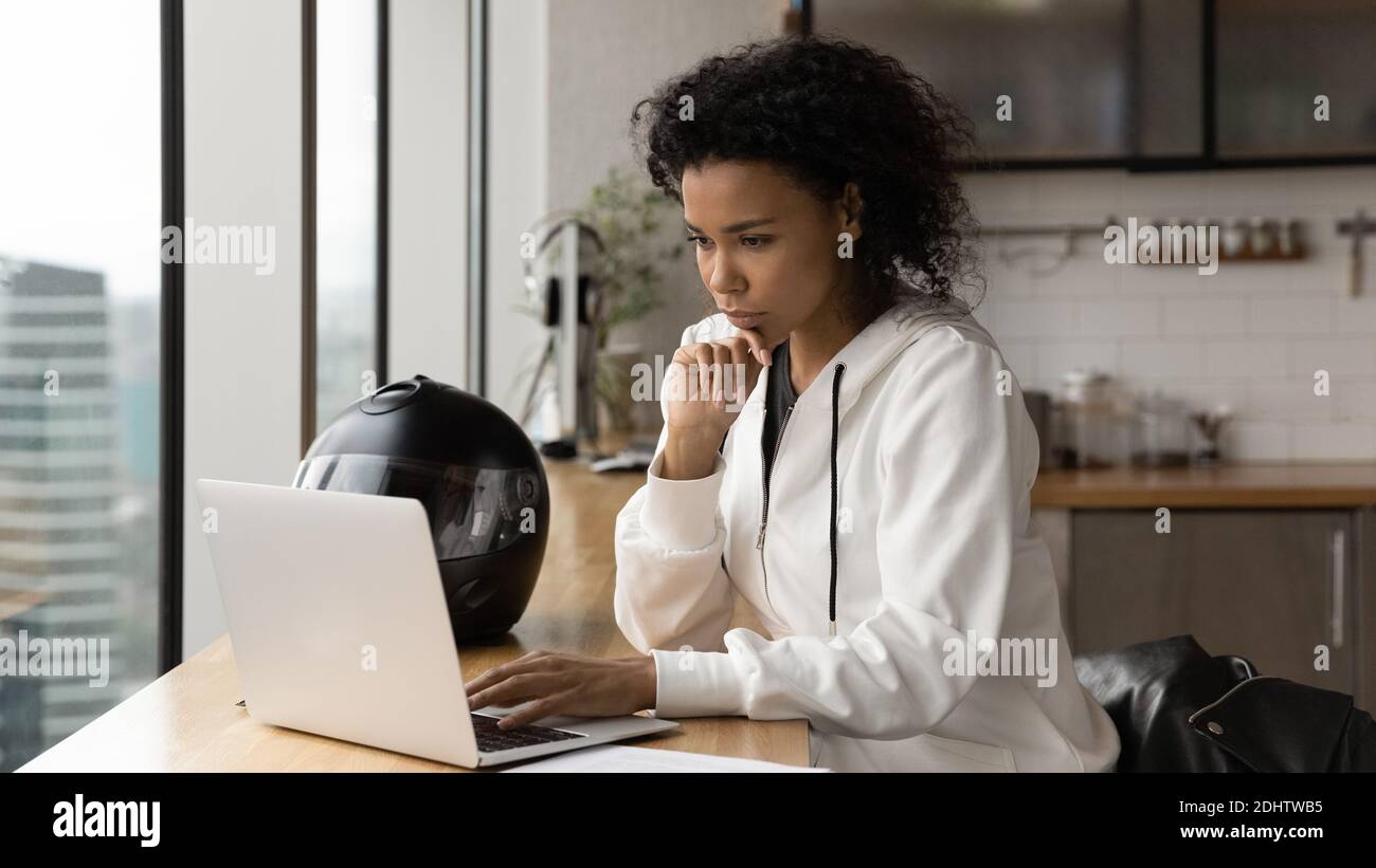 Pensive biracial weiblich arbeiten auf Laptop am Schreibtisch Stockfoto