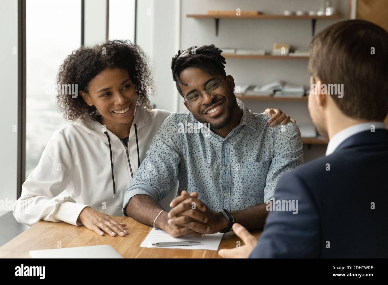Glückliches biracial Paar haben Treffen männlichen Makler Stockfoto