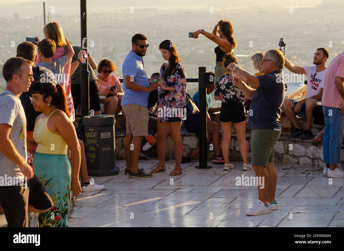 Touristen machen Schnappschüsse auf ihren Smartphones am Aussichtspunkt auf dem Lycabettus-Hügel im Zentrum Athens Griechenland - Foto: Geopix Stockfoto
