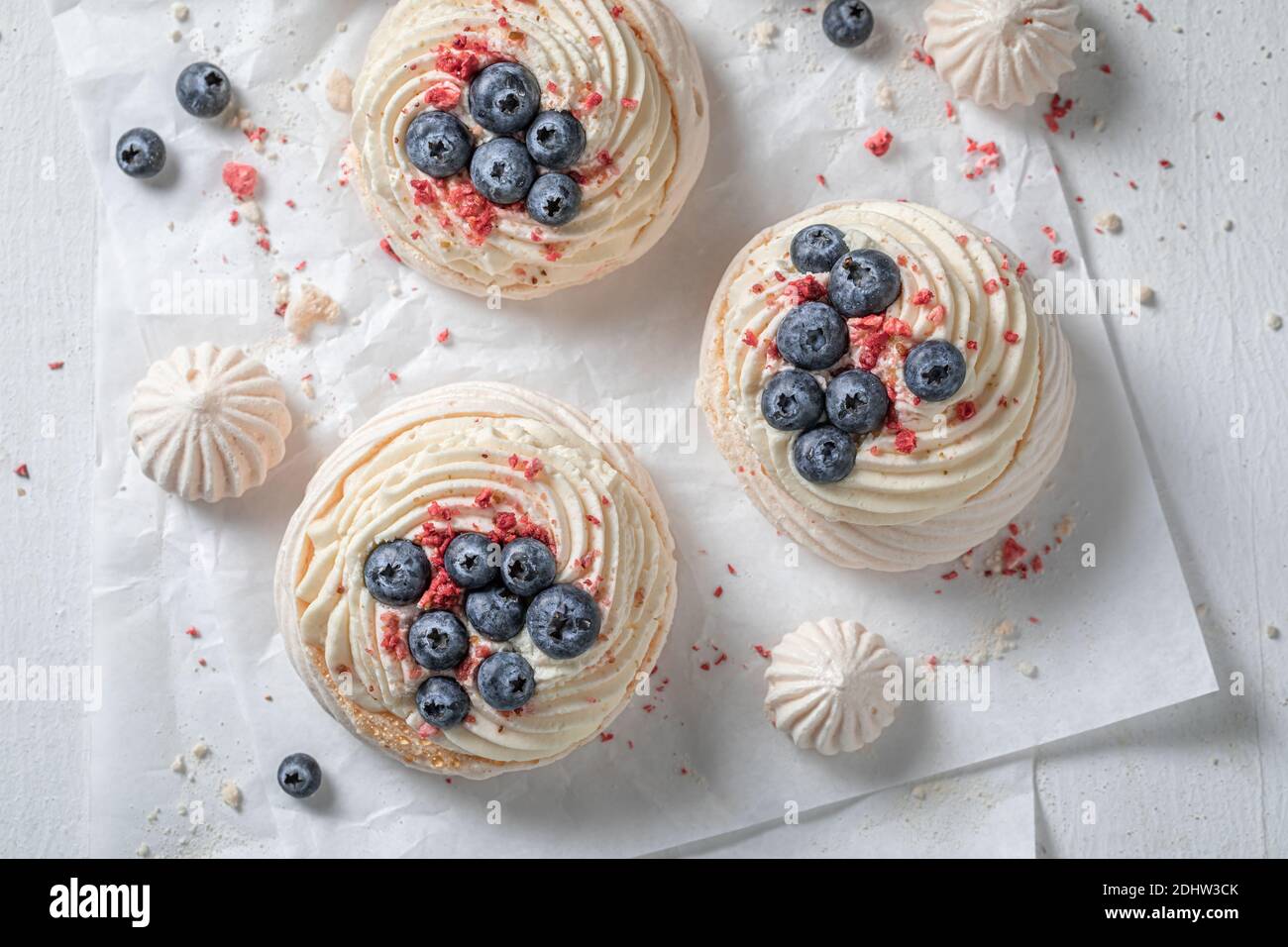 Knackiger Mini Pavlova mit Schlagsahne und frischem Obst Backpapier Stockfoto