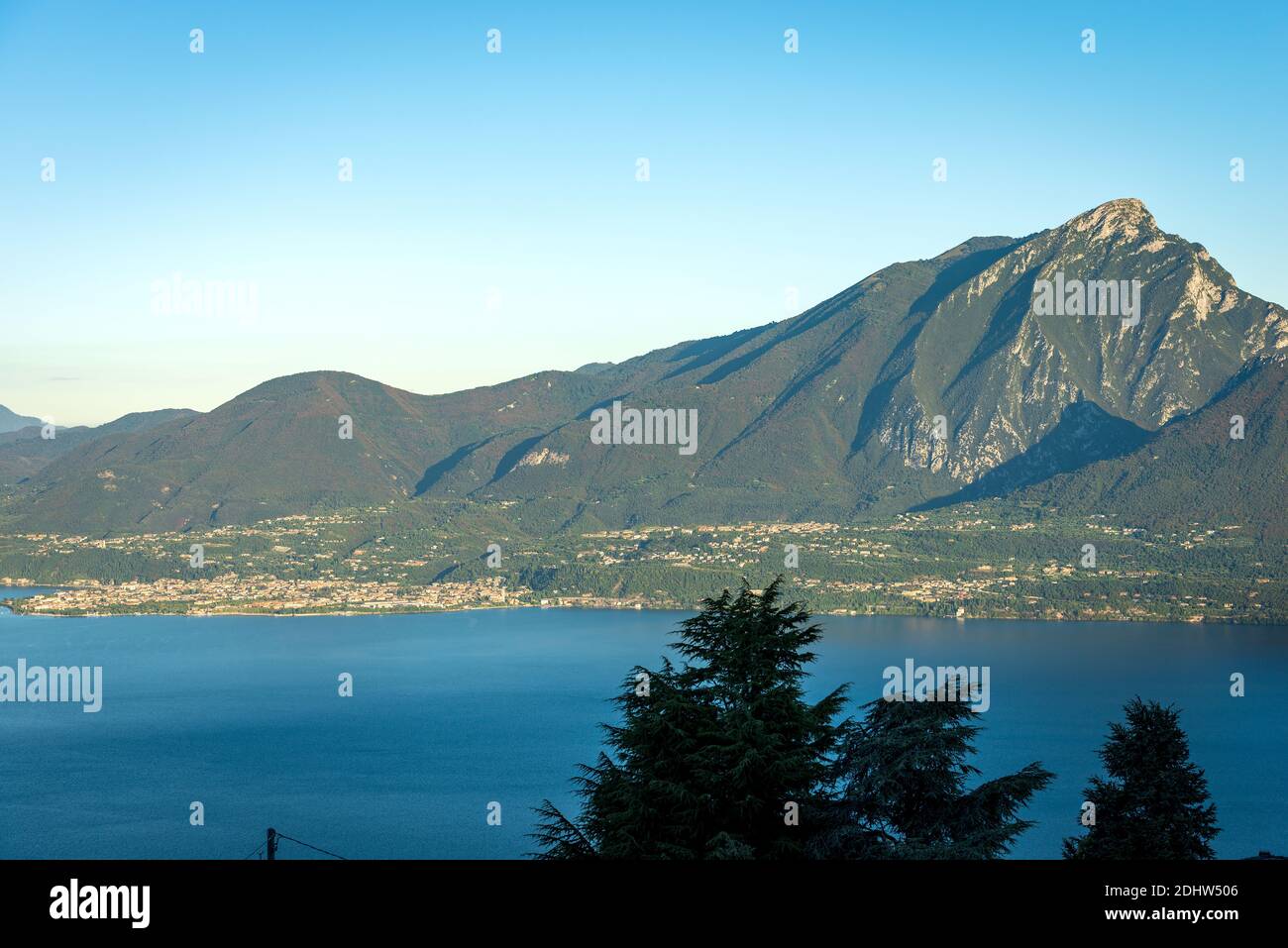 Luftaufnahme des Gardasees und der italienischen Alpen mit dem Gipfel des Monte Pizzocolo und der kleinen Stadt Toscolano und Maderno. Lombardei Küste, Italien. Stockfoto