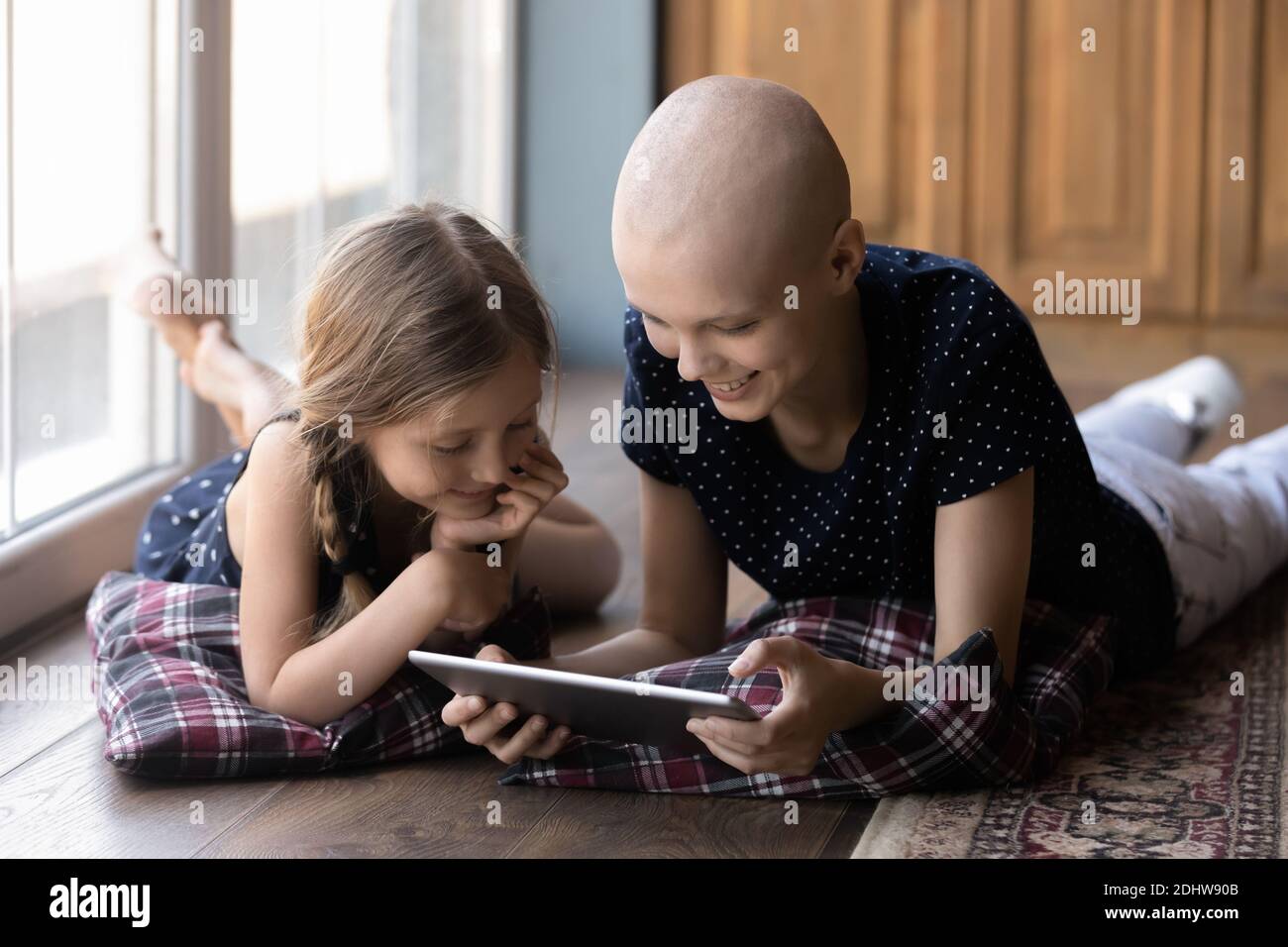 Glücklich krank haarlose Mutter und kleines Mädchen mit Tablette zusammen Stockfoto