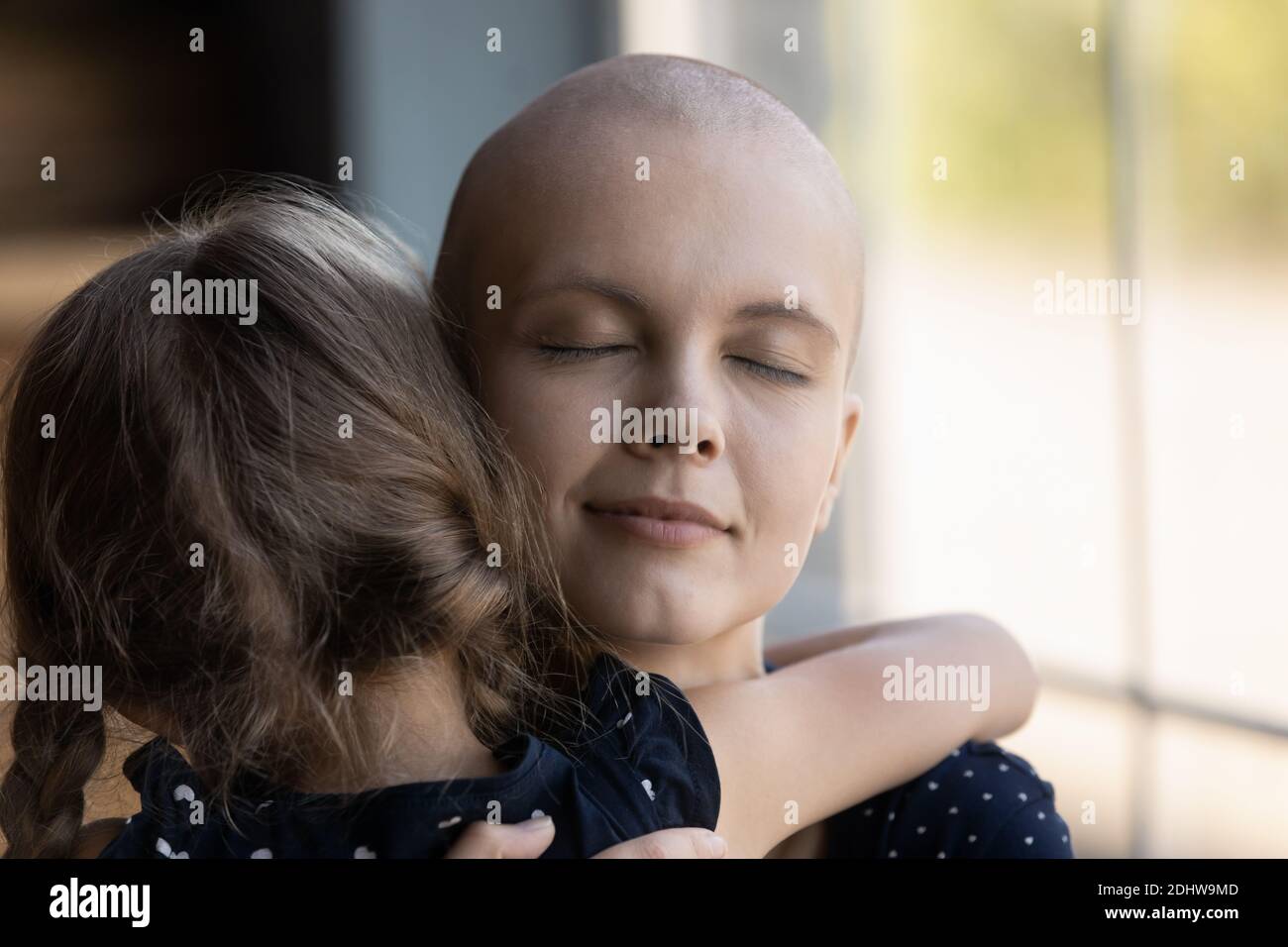 Nahaufnahme liebevolle kranke haarlose Mutter umarmt kleine Tochter Stockfoto
