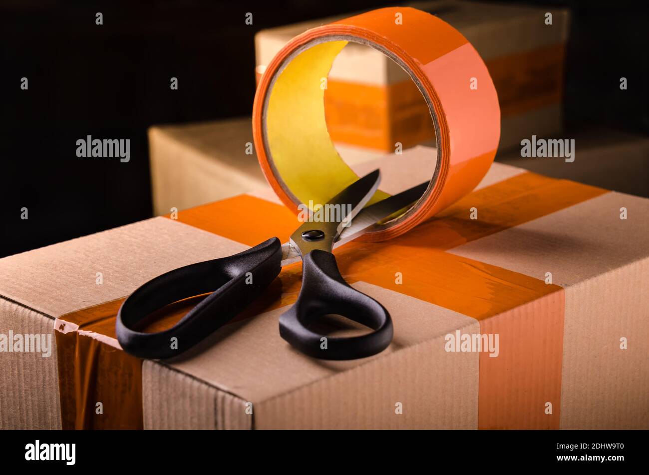 Schere und Scotch Tape Box auf dunklem Hintergrund Stockfoto