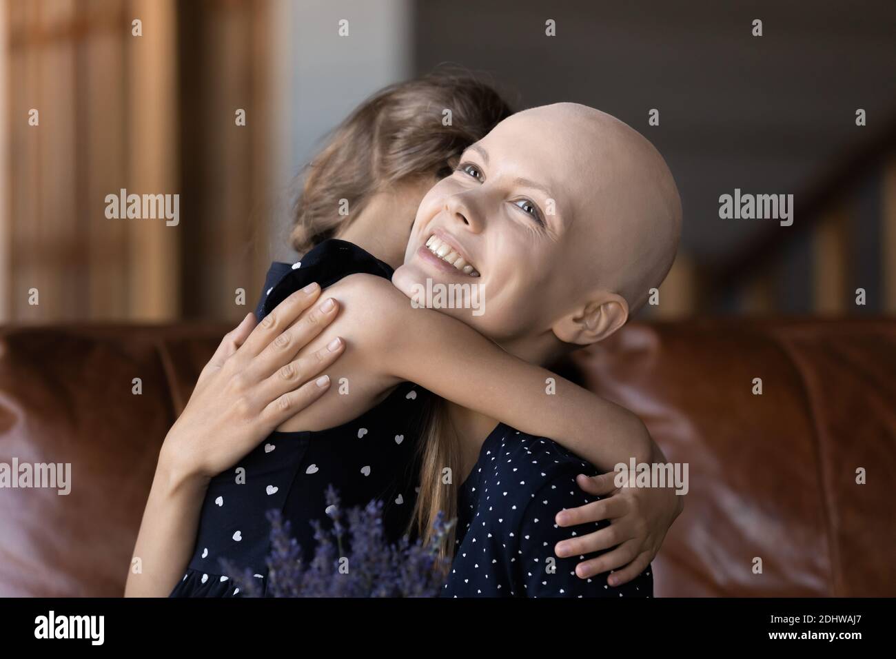 Nahaufnahme lächelnd haarlose Frau Krebs-Patientin umarmt kleine Tochter Stockfoto