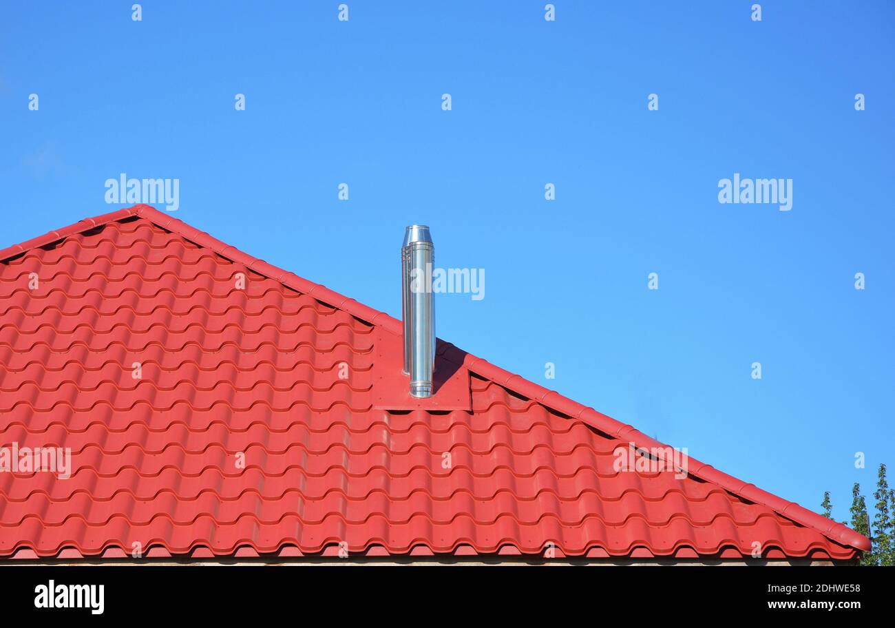 Neues rotes Ziegeldach mit Metallkamin Haus Dachkonstruktion außen. Stockfoto