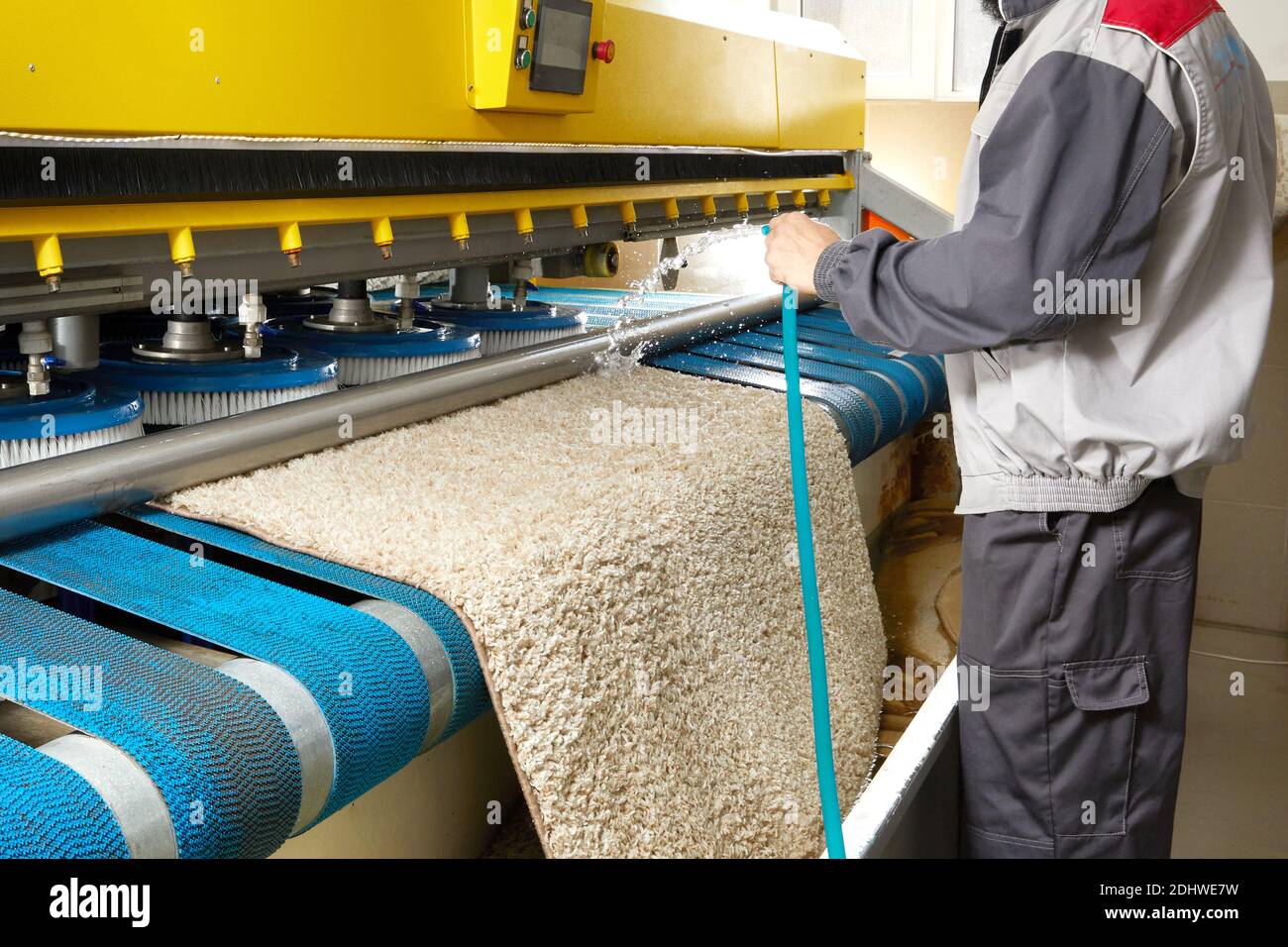 Männlicher Arbeiter Reinigung Teppich auf automatische Waschmaschine  Ausrüstung und Trockner im Waschraum. Professioneller Waschservice  Stockfotografie - Alamy
