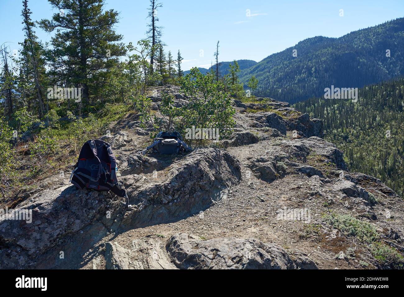 Zwei Wanderrucksäcke befinden sich auf einem kleinen, felsigen Plateau am Ende des Liberty Falls Trail, über Bergen mit dichten Wäldern. Stockfoto