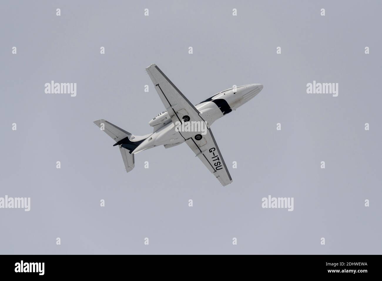 Sovereign Business Jets Embraer EMB 500 Phenom 100 G-ITSU Corporate Jet Flugzeug fliegen unter Schneewolken über London Southend Airport verbinden. Unterseite Stockfoto