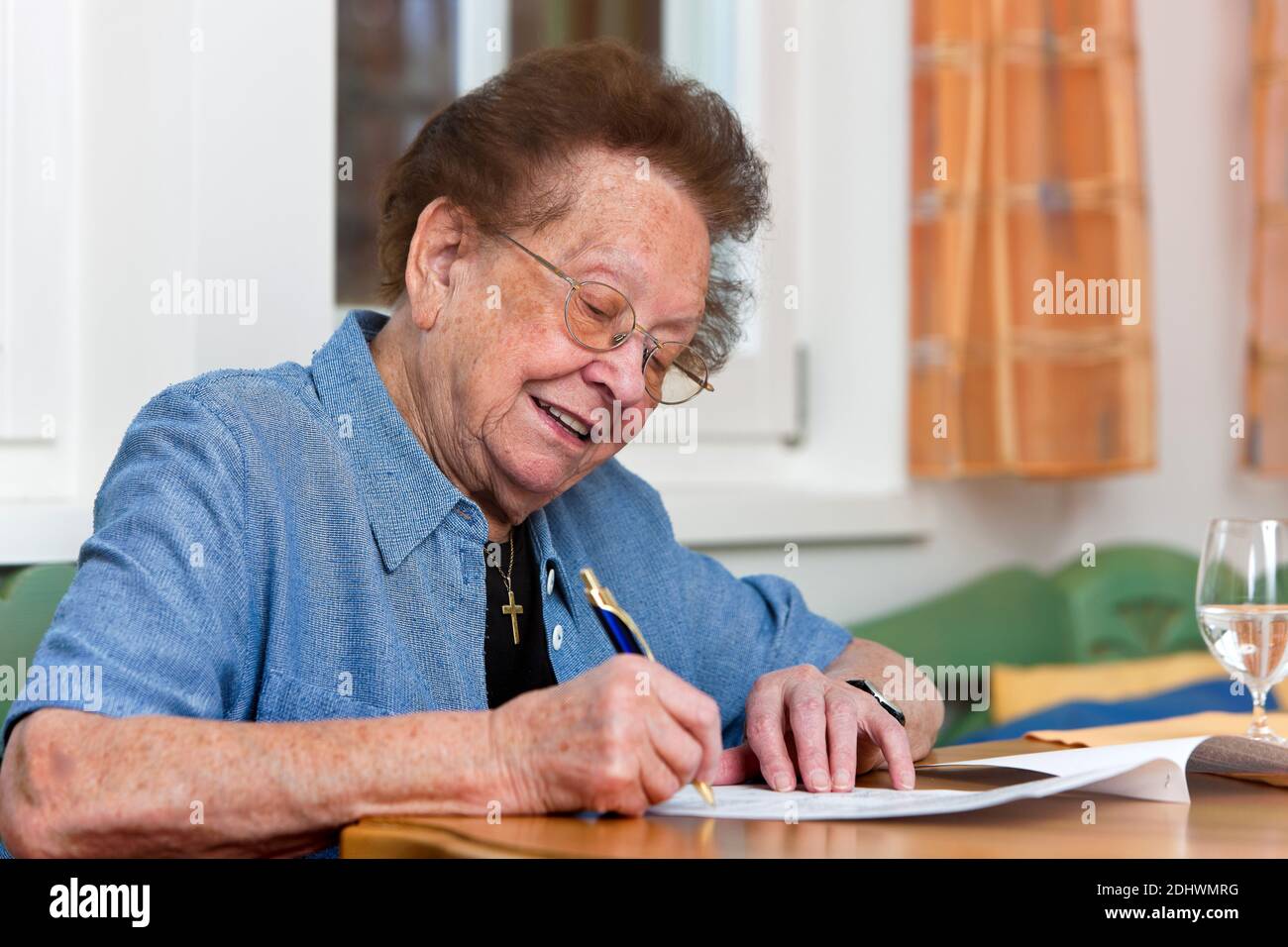 Eine alte Frau schreibt einen Vertrag, Senioren, Stockfoto