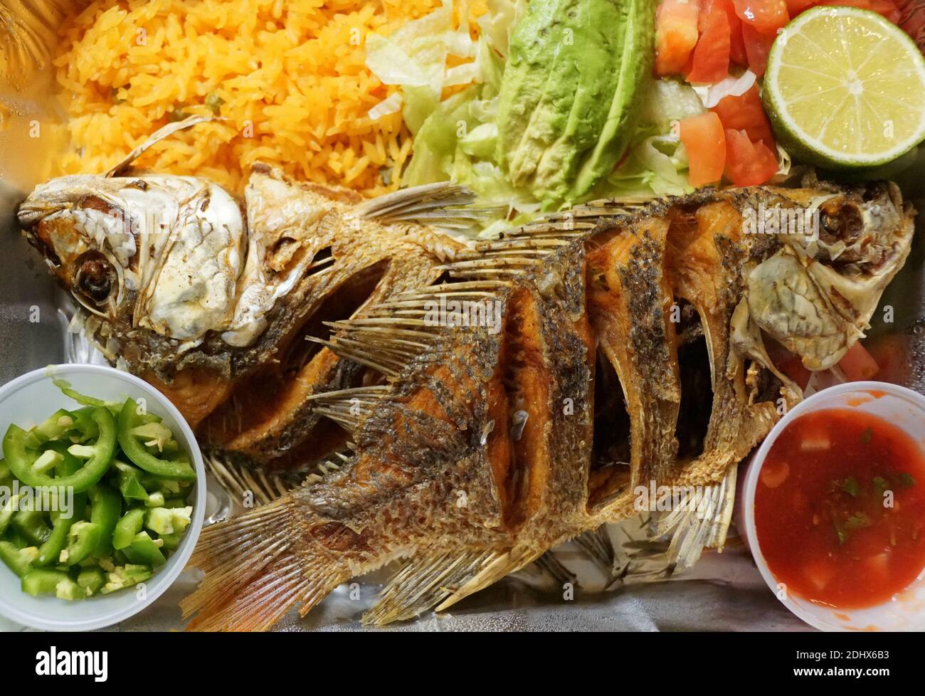 Pescado Frito, ein mexikanisches Gericht mit gebratener Tilapia, gelbem Reis und Salat Stockfoto