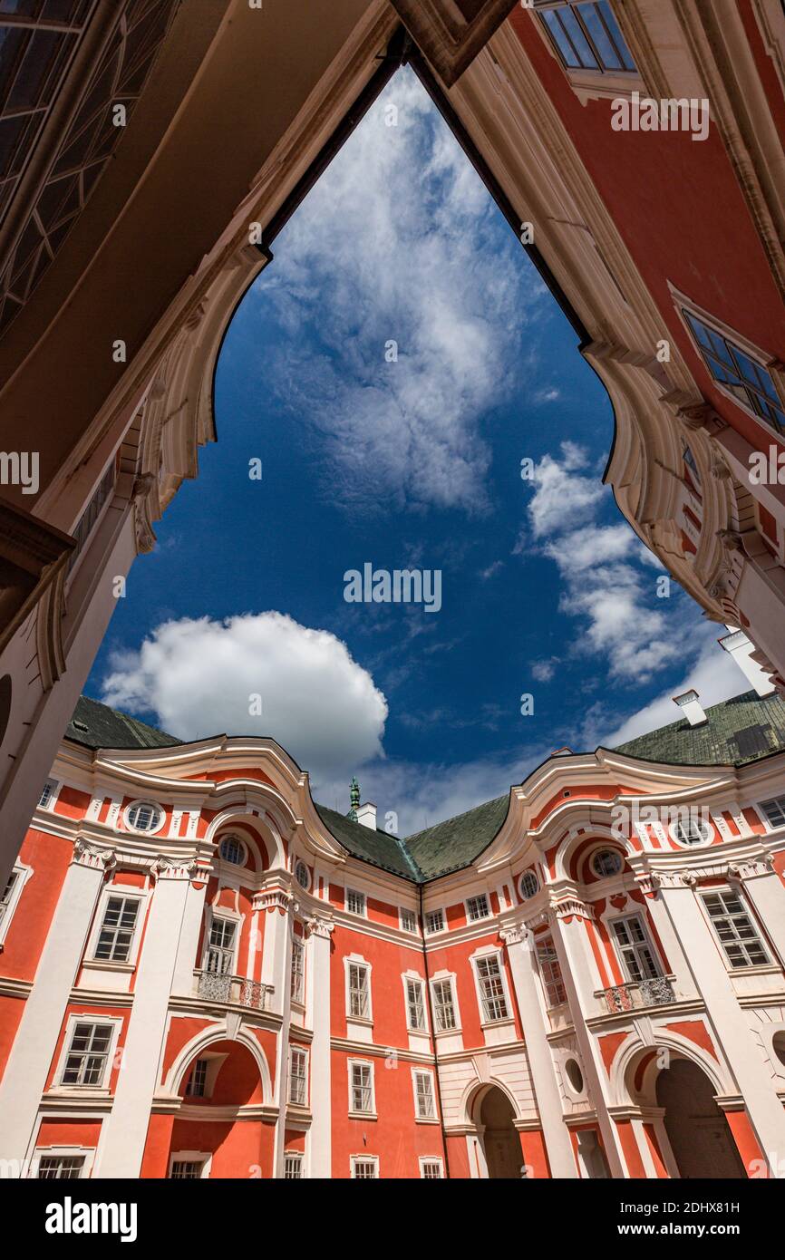 Broumov, Tschechische Republik - Juni 17 2020: Das berühmte Benediktinerkloster mit rot-weißer Fassade. Ansicht von unten. Sonniger Sommertag mit blauem Himmel. Stockfoto Broumov, Tschechische Republik - Juni 17 2020: Das berühmte Benediktinerkloster mit rot-weißer Fassade. Ansicht von unten. Sonniger Sommertag mit blauem Himmel. Stockfoto