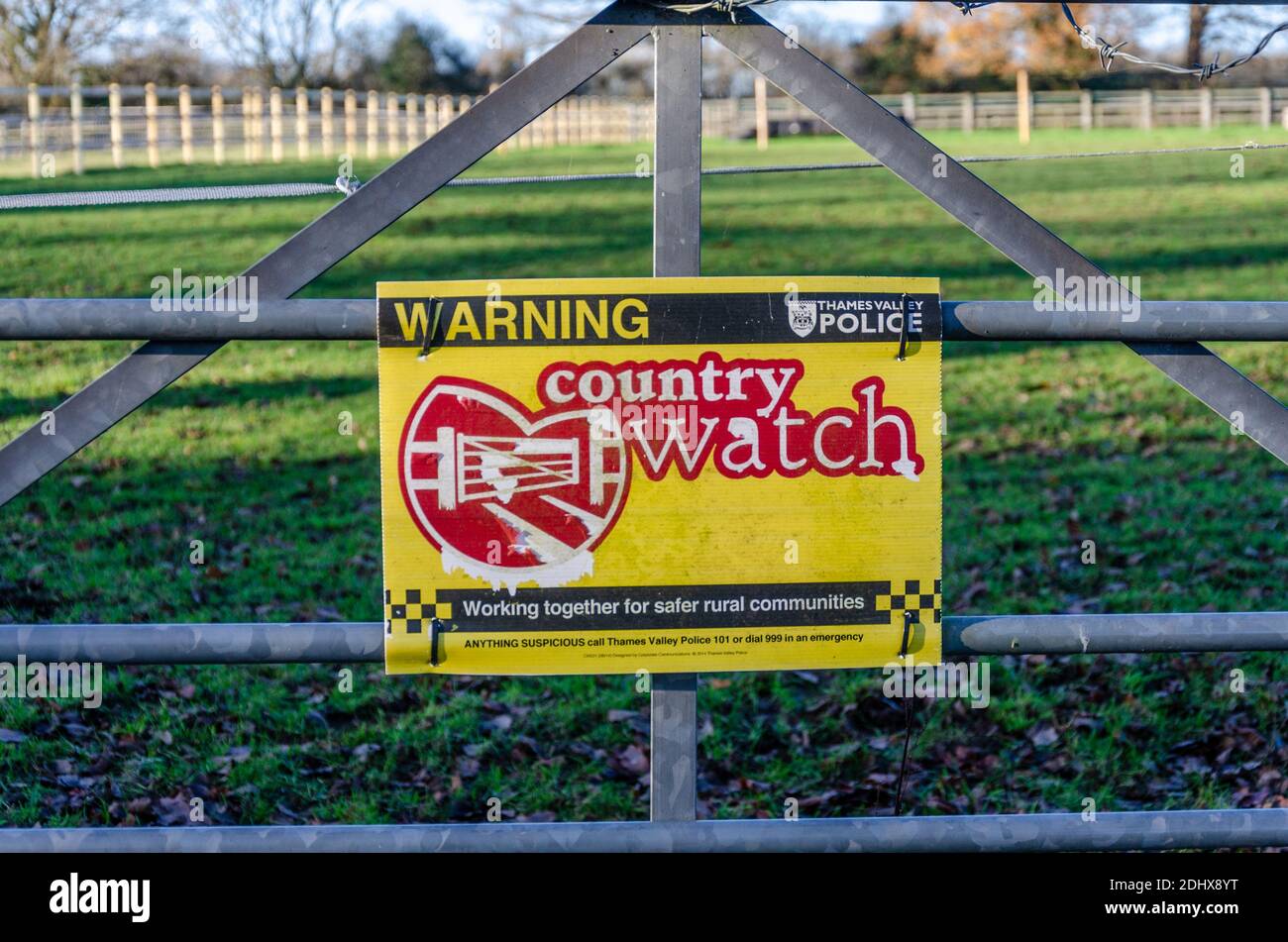 Ein Schild an einem Metalltor am Eingang zu einem Feld warnt die Menschen, dass in diesem Bereich eine Landuhr in Kraft ist. Stockfoto