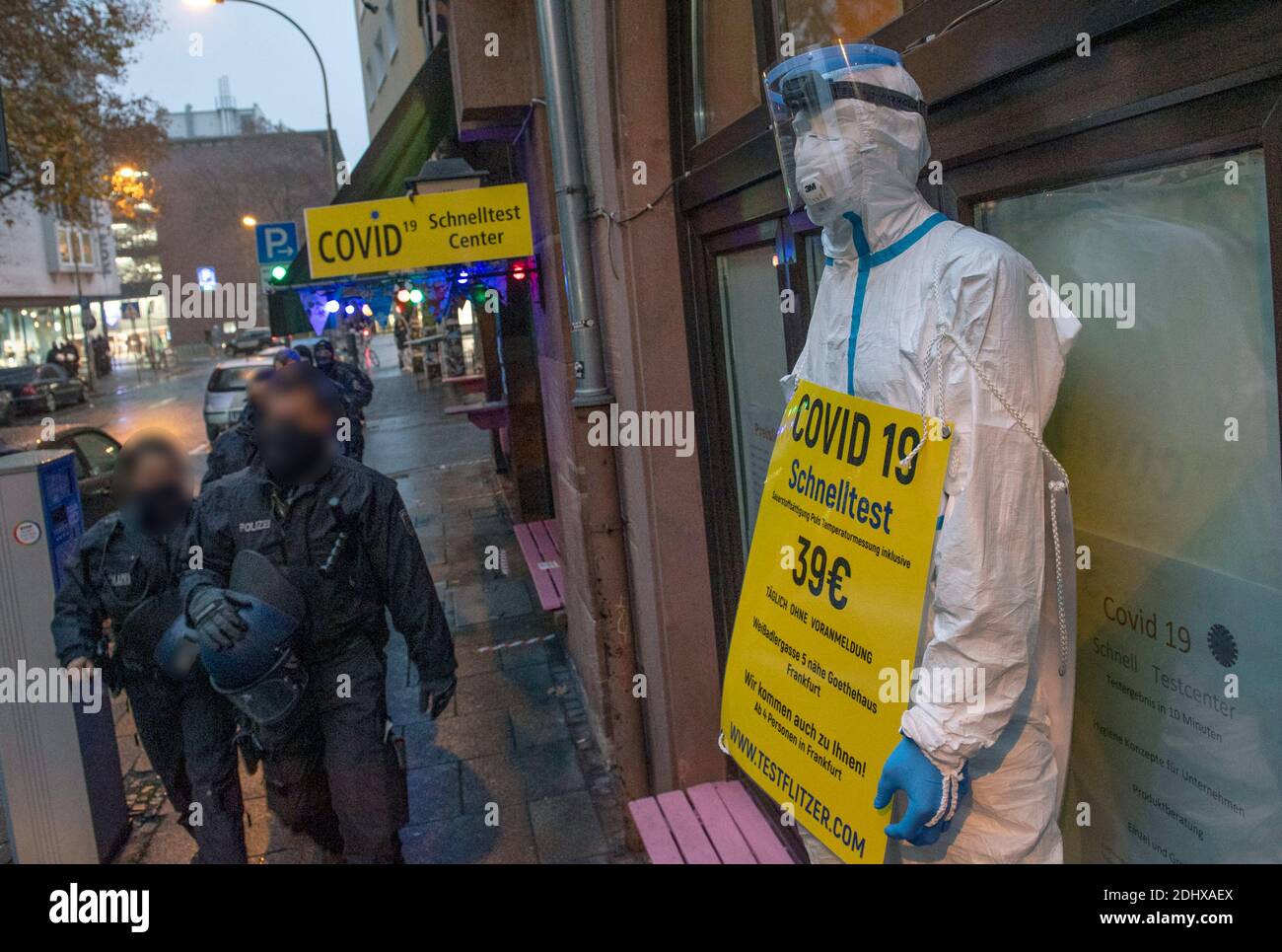 12. Dezember 2020, Hessen, Frankfurt/Main: Eine lebensgroße Puppe in Schutzkleidung und mit einem Schild, das Covid-19 Schnelltests für 39 Euro anbietet, steht vor einem neuen Corona Schnelltestzentrum, zu dem der Besitzer seine Tequila-Bar in der Innenstadt umgebaut hat. Dort, wo abends meist Dutzende von Gästen starten, wartet nun medizinisches Personal in Schutzkleidung auf Gäste der etwas anderen Art. Foto: Boris Roessler/dpa Stockfoto