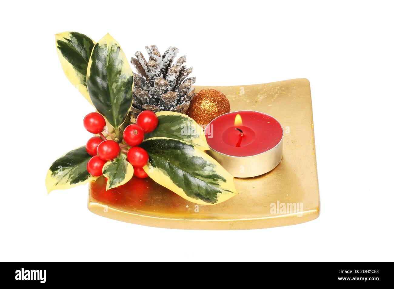 Weihnachtstisch Herzstück, bunte Stechpalme, Pinecone, Kugel und Kerze auf einer goldenen Schale isoliert gegen weiß Stockfoto