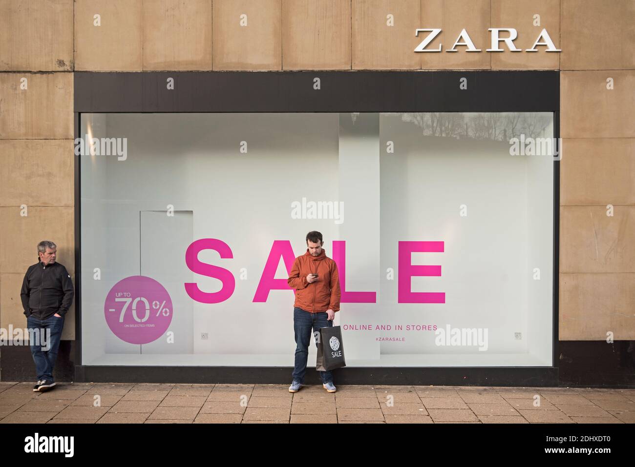 Zara Laden mit einem Verkaufsschild und Männer warten draußen. Princes  Street. Edinburgh, Schottland, Großbritannien Stockfotografie - Alamy