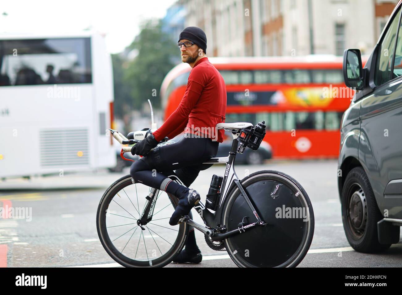 GROSSBRITANNIEN /England/ Männlich auf einem Fahrrad, das auf einer Straße in der City of London, London, Großbritannien, auf Verkehr wartet. Stockfoto
