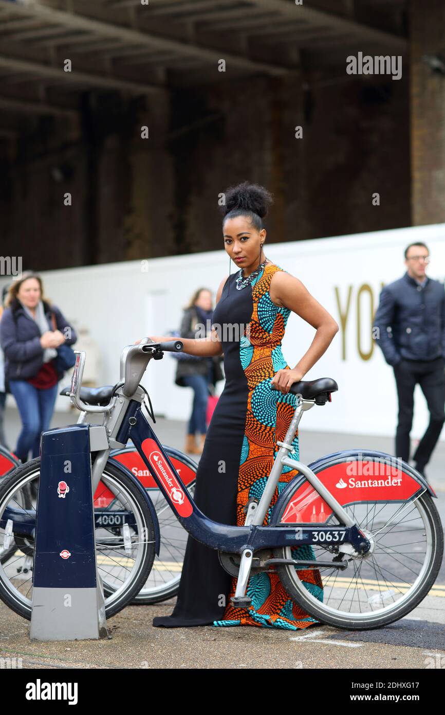 Mädchen mit bunten Kleid mit dem Santander Fahrrad mieten Scheme in London, Großbritannien Stockfoto