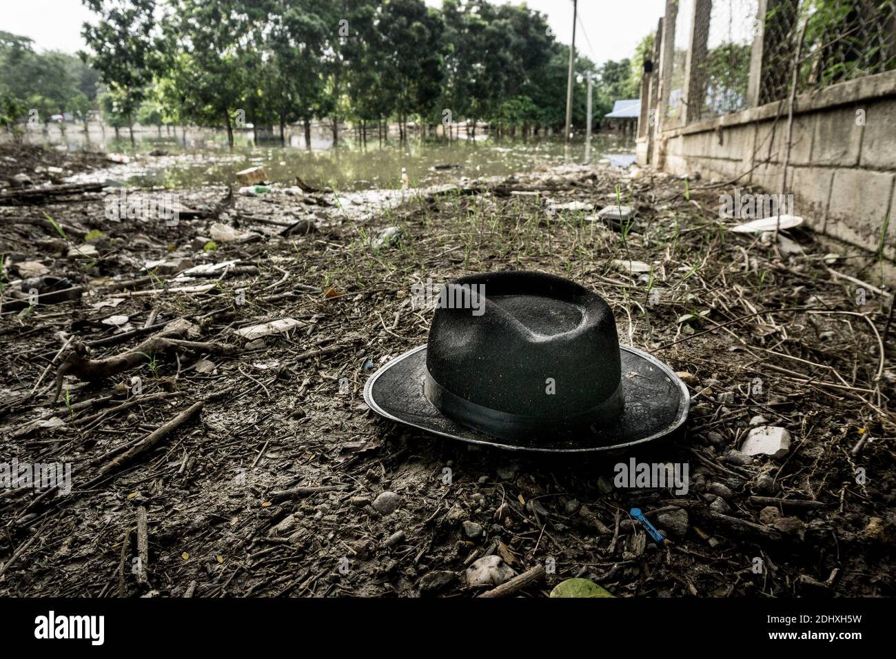 Ein weggeworfener Hut auf dem schlammigen Ufer einer von Hurrikan Eta und Hurrikan Iota überschwemmten Straße in La Lima, Honduras Stockfoto