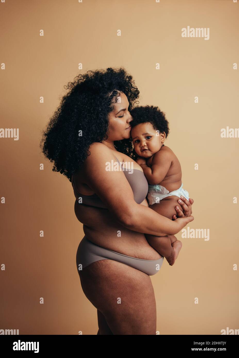 Afroamerikanische Frau und Baby. Mutter hält ihr niedliches Baby in den Armen. Stockfoto