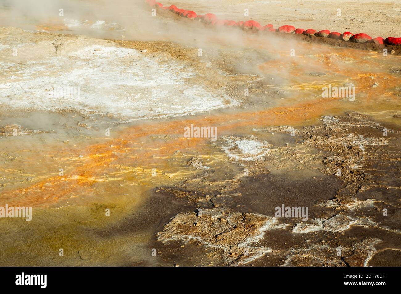 Rote Steine umschließen Blattflüsse, die gelben Schwefel und andere Mineralien auf El Tatio Geysir Feld und Geothermie Gebiet, die Anden, Chile Stockfoto