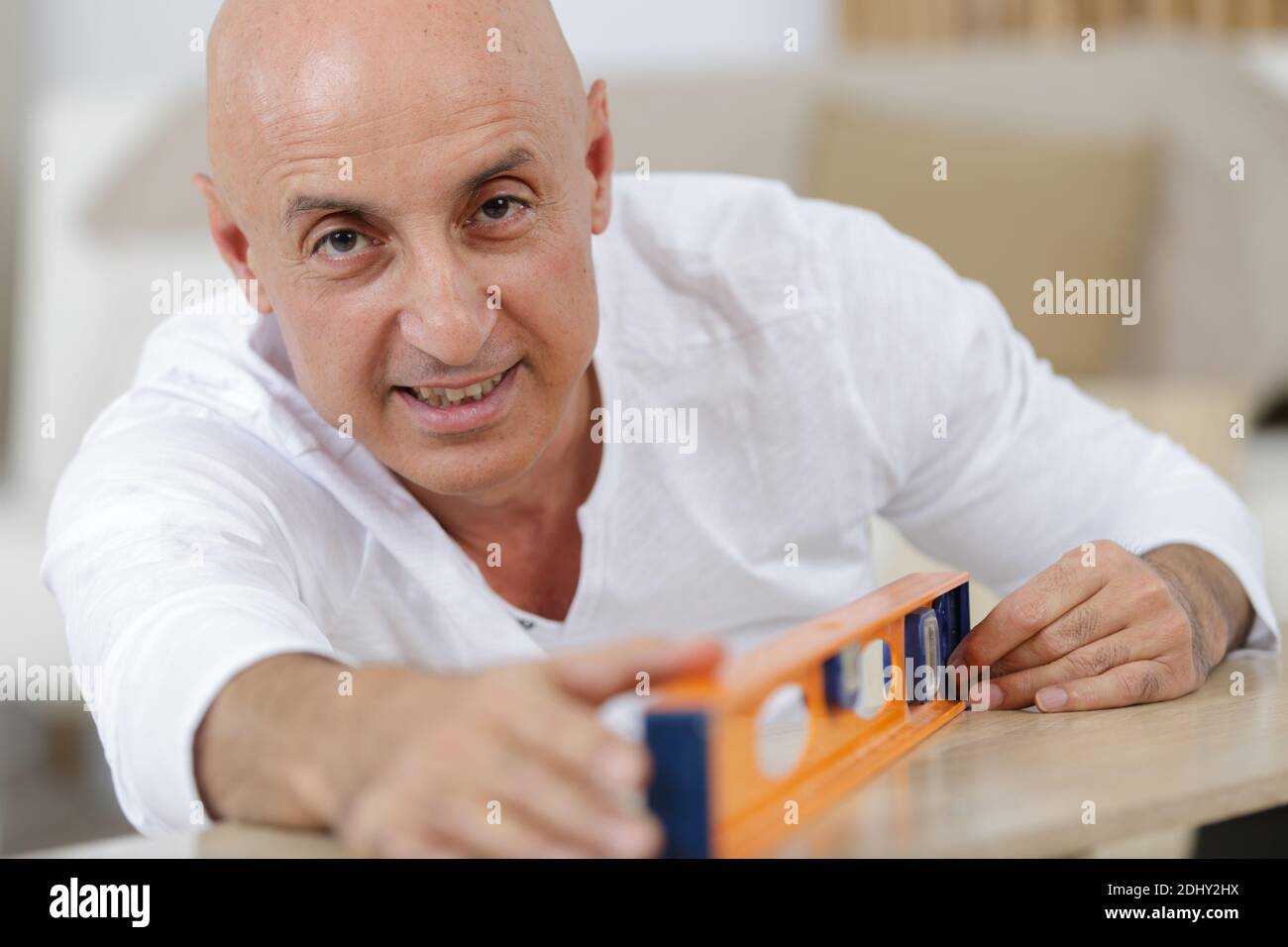 Mann mittleren Alters Messung Holzstück für Möbel Montage Stockfoto