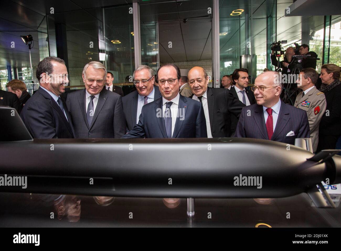 Der französische Präsident Francois Hollande und der Minister für auswärtige Angelegenheiten und internationale Entwicklung, Jean-Marc Ayrault, DCNS-CEO Herve Guillou, Verteidigungsminister Jean-Yves Le Drian und Innenminister Bernard Cazeneuve vor einem DCNS-Modell mit Kurzflossen-Barrakuda bei einem Besuch im Hauptsitz der DCNS-Gruppe anlässlich der neuen Partnerschaft des Unternehmens mit der Royal Australian Navy (RAN) am 26. April 2016 in Paris, Frankreich. DCNS, eine französische Industriegruppe, die sich auf die Verteidigung und Energie der Marine spezialisiert hat, unterzeichnete einen 34-Milliarden-Euro-Vertrag mit der australischen Marine für den Bau Stockfoto