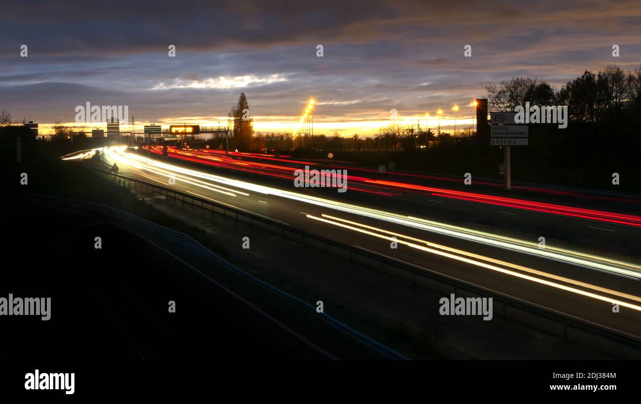 Leichte Spur der Autos auf der Autobahn während des Morgens. Gesponnene Fahrzeuge auf der Straße von einer Brücke aus gesehen. Lightspainting-Szene. Stockfoto