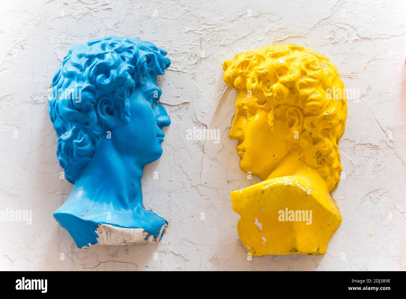 Zwei Statuen von david mit Farben von Gelb und Blau an der Wand in Dafen Ölgemälde Dorf, Shenzhen, China. Stockfoto