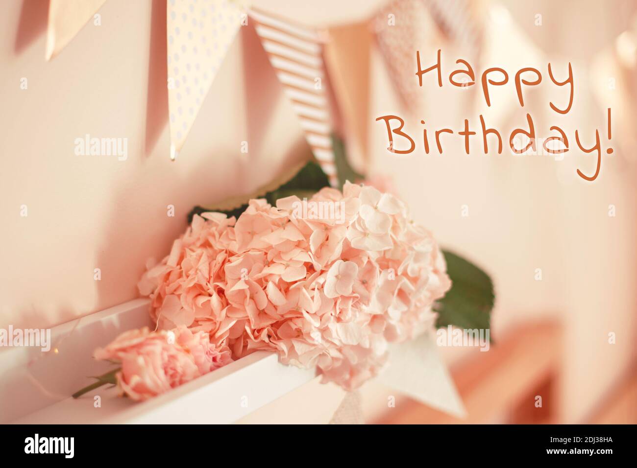 Happy Birthday Karte mit Grußtext. Zimmerdekoration in rosa beige neutralen Farben für Geburtstagsfeier. Makro-Nahaufnahme von hellrosa Hortensien Stockfoto
