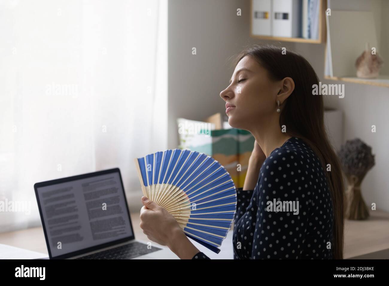 Nahaufnahme erschöpft Frau winkende Papierventilator am Arbeitsplatz Stockfoto