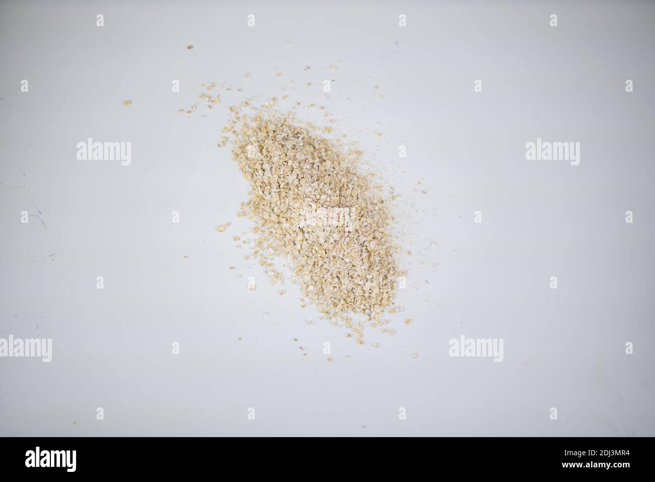 Kleiner Stapel dunkles Roggenmehl auf einem weißen Tisch Stockfoto