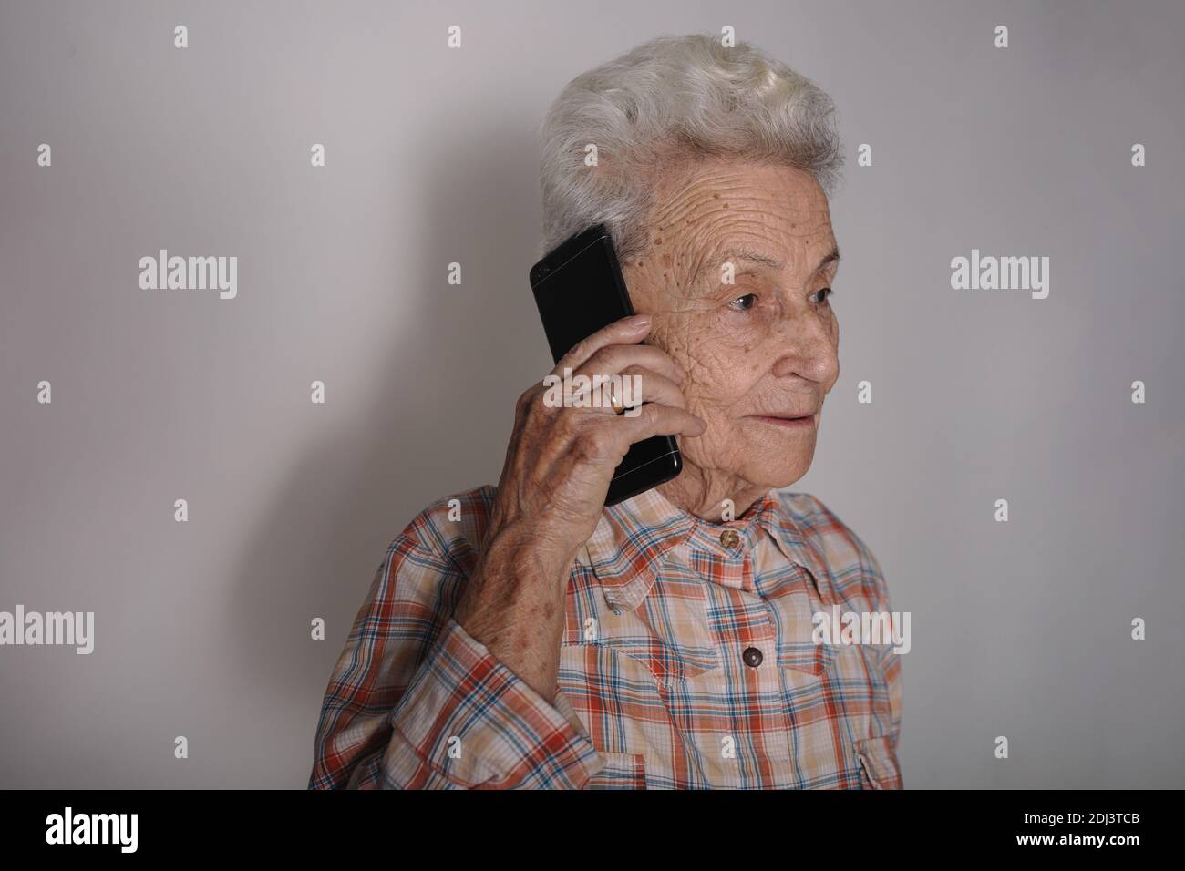 Ältere Person mit dem Smartphone, die einen Anruf macht, angenehme Unterhaltung hat, chattet, gute Nachrichten hört Stockfoto