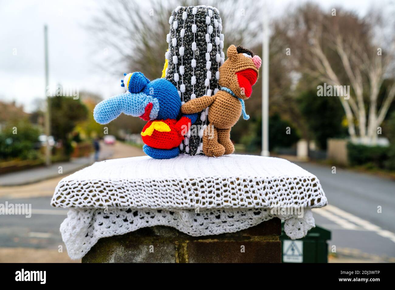 Britische traditionelle rote Briefkästen mit Strickmützen als Weihnachtsdekoration. Muppet Figuren aus der berühmten TV-Show. Stockfoto