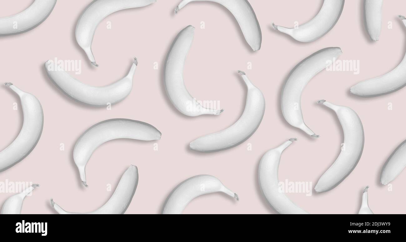 Muster aus weißen tropischen Bananen auf pastellrosa Hintergrund. Kreatives Minimal Art Konzept. Vektorgrafik. Flach liegend. Stockfoto
