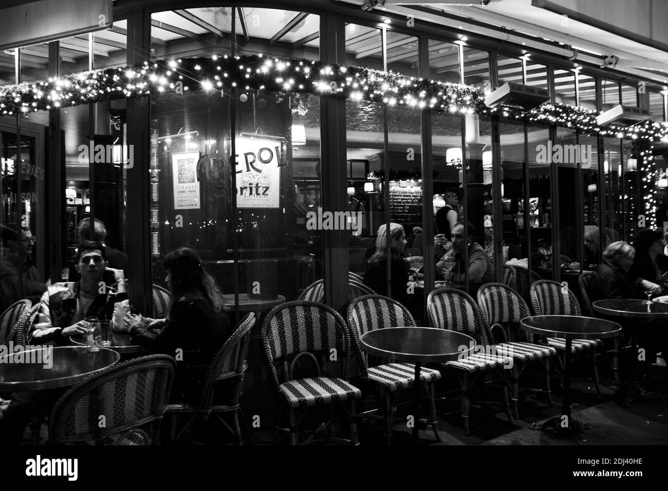 PARIS, FRANKREICH - 2. DEZEMBER 2018: Pariser und Touristen trinken abends im Café Panis (bereits zu Weihnachten dekoriert) in der Nähe von Notre-Dame Stockfoto