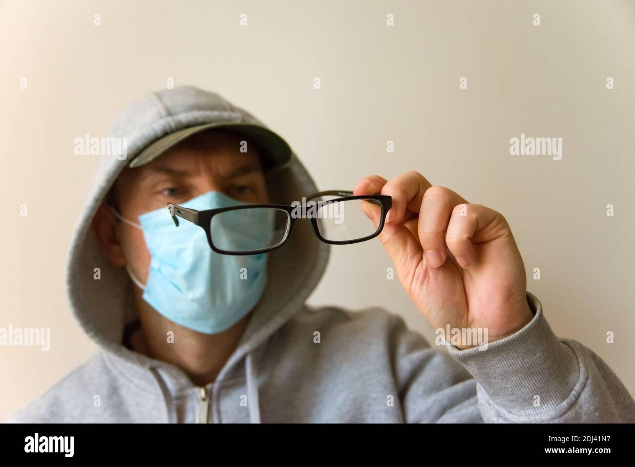 Der Mann in der Maske schaut auf das Schwarz Brille Stockfoto