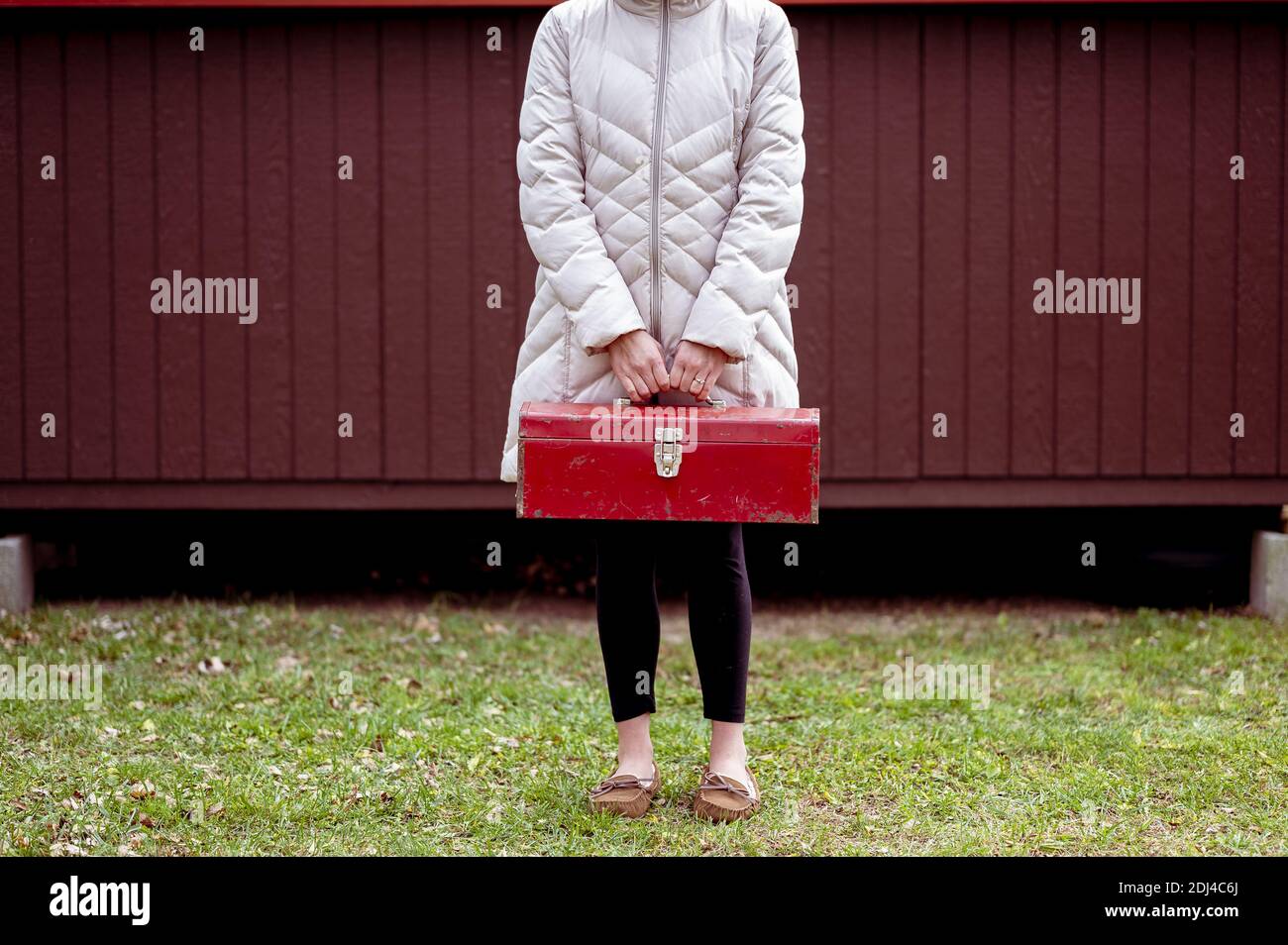 Nahaufnahme eines Oberschenkelknochens, das einen Werkzeugkasten hält Stockfoto