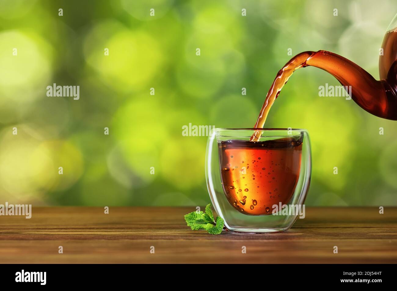 Tee aus der Teekanne in die Tasse gießen Stockfoto