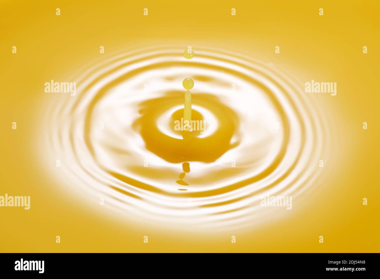 Tropfen, der auf Orangensaft fällt Stockfoto
