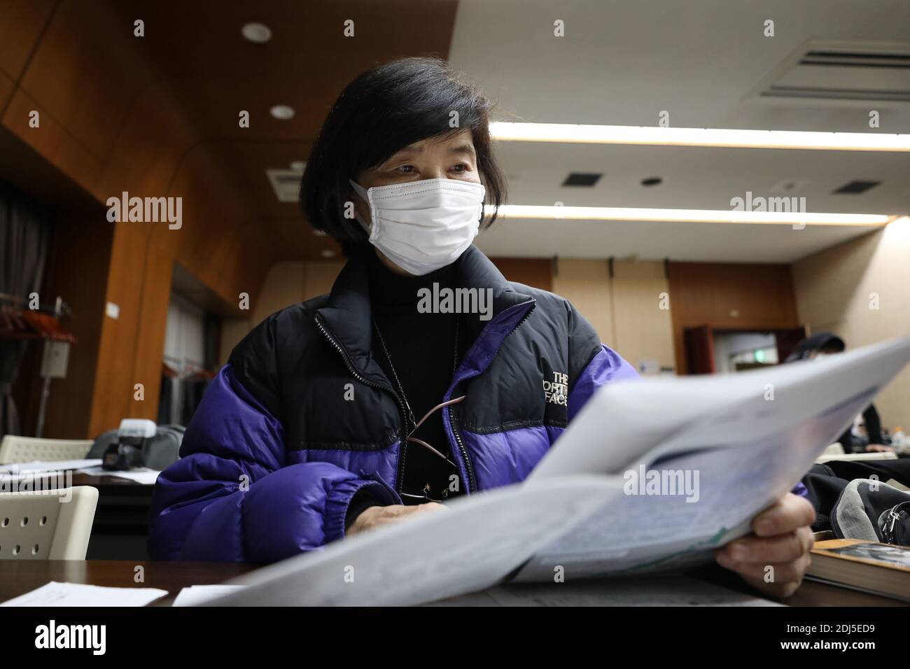 Tokio, Japan. Dezember 2020. Etsuko Sato geht bei der Kundgebung anlässlich seines 83. Jahrestages in Tokio, Japan, am 13. Dezember 2020 Materialien über das Massaker von Nanjing durch. Japanische Zivilgruppen veranstalteten hier am Sonntag eine Kundgebung zum 83. Jahrestag des Massakers von Nanjing, um die Opfer zu betrauern und die brutalen Verbrechen der japanischen Invasoren aufzudecken, und riefen die Menschen dazu auf, sich der Geschichte zu erinnern und eine friedliche und freundliche Zukunft zu schaffen. Quelle: Du Xiaoyi/Xinhua/Alamy Live News Stockfoto