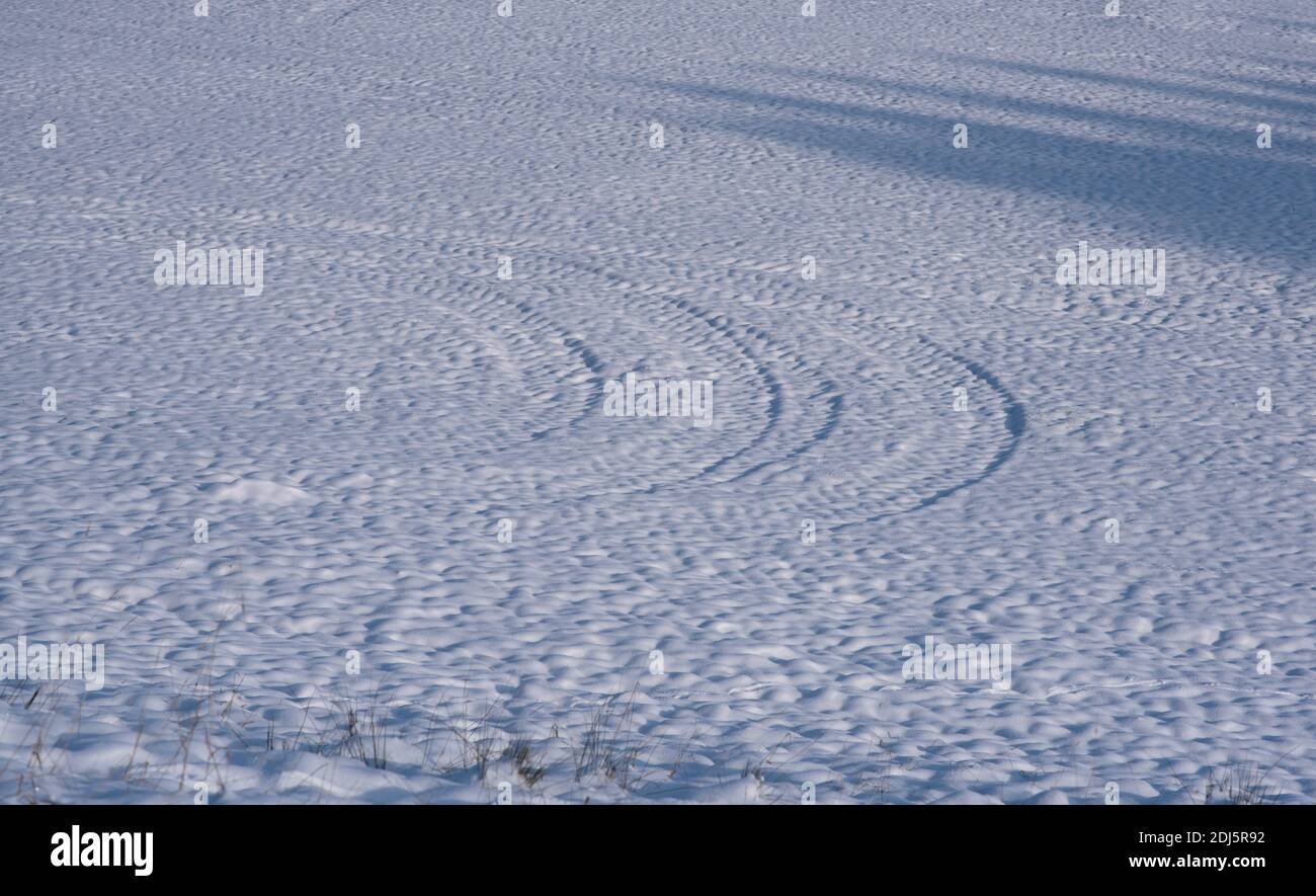 Spuren von Traktor auf dem Schnee in einem sonnigen Winter Tage Stockfoto