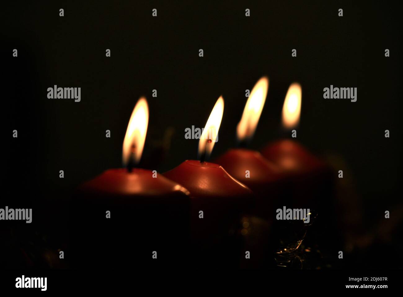 Nahaufnahme eines Adventsarrangements mit vier brennenden Kerzen Stockfoto